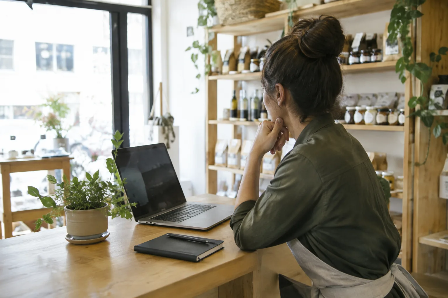 Une personne consulte des retours clients sur un ordinateur posé sur le comptoir d’un commerce.